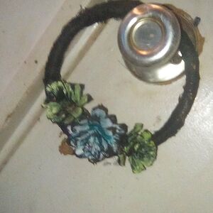 Small hand made wreath covered in black lace with three small "pinecone roses"